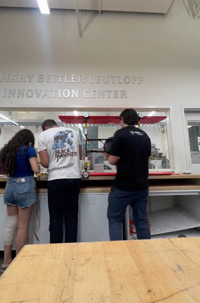 Team members working on the drone frame in the fabrication lab